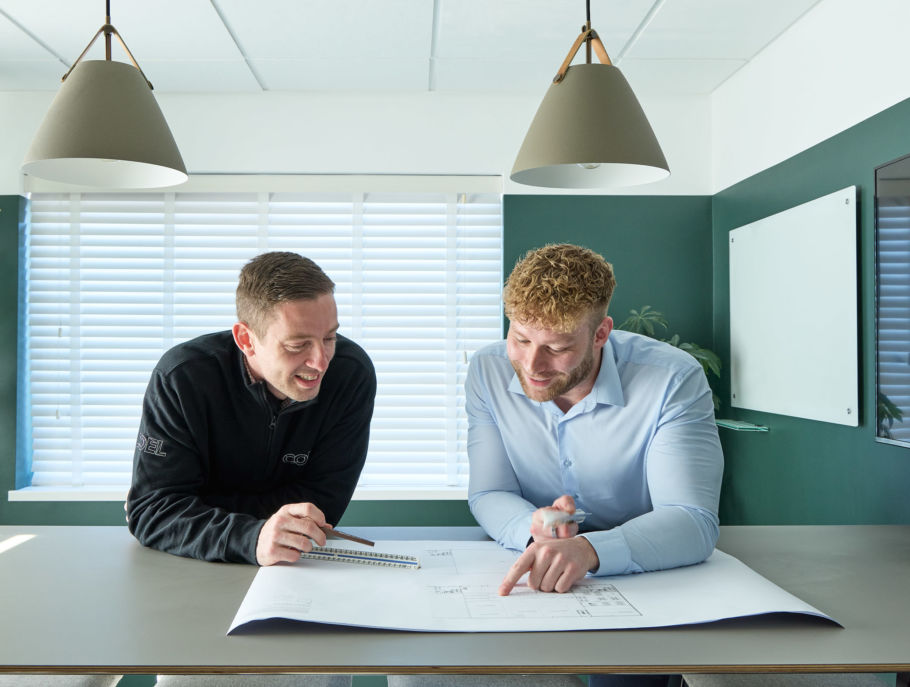 Two men reviewing architectural plans on a table