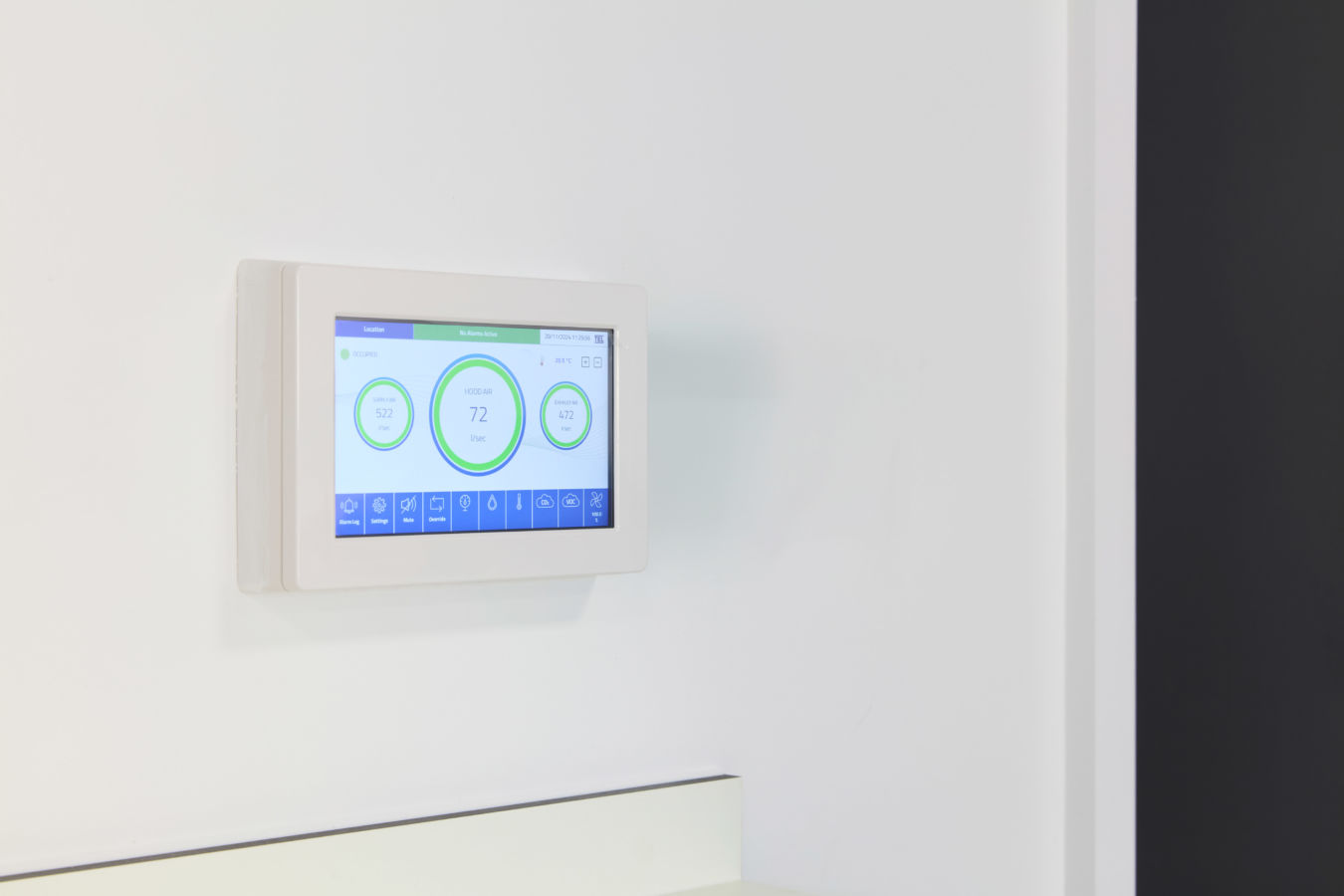 digital wall-mounted thermostat displays temperature and other climate control information on a touchscreen interface