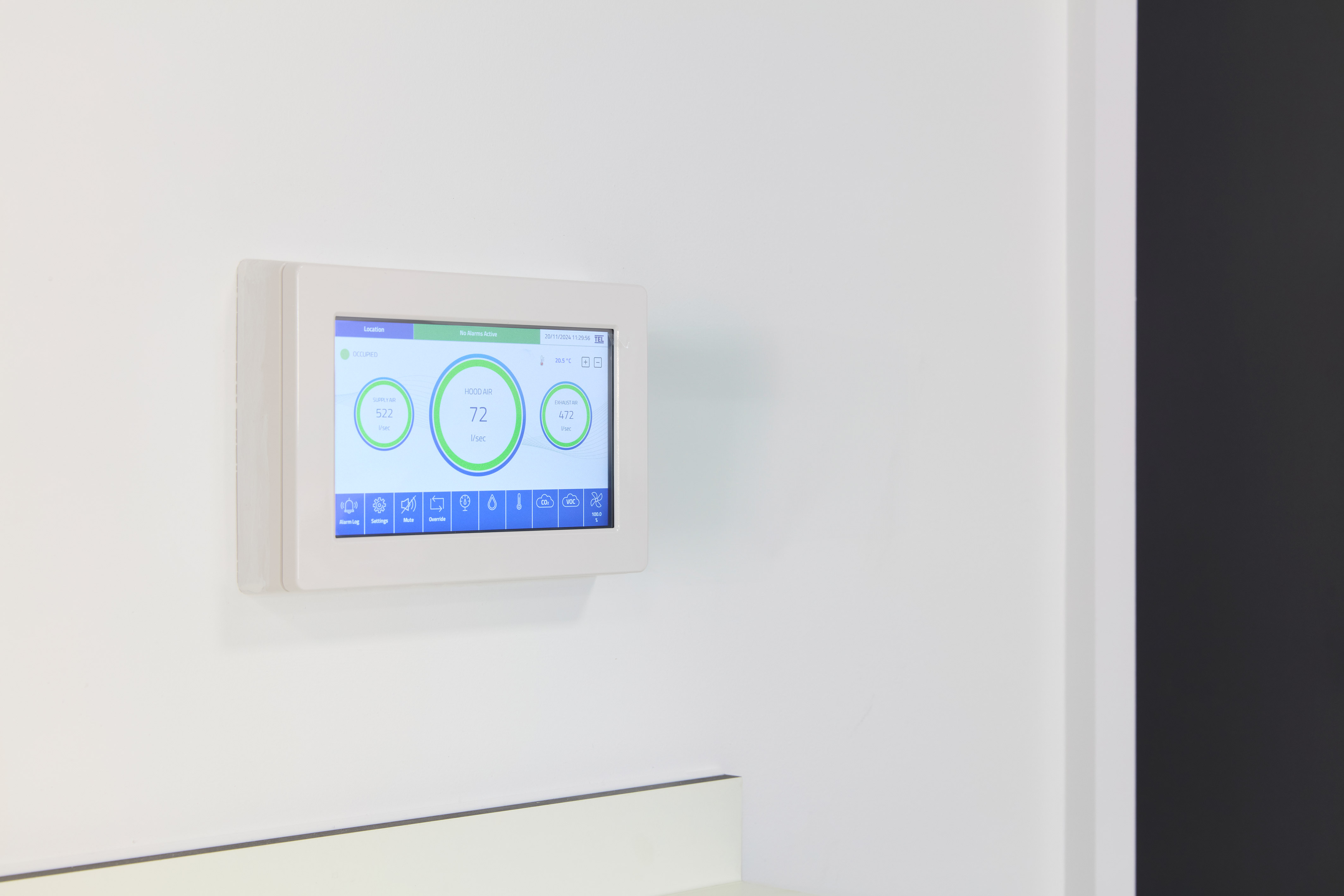 digital wall-mounted thermostat displays temperature and other climate control information on a touchscreen interface