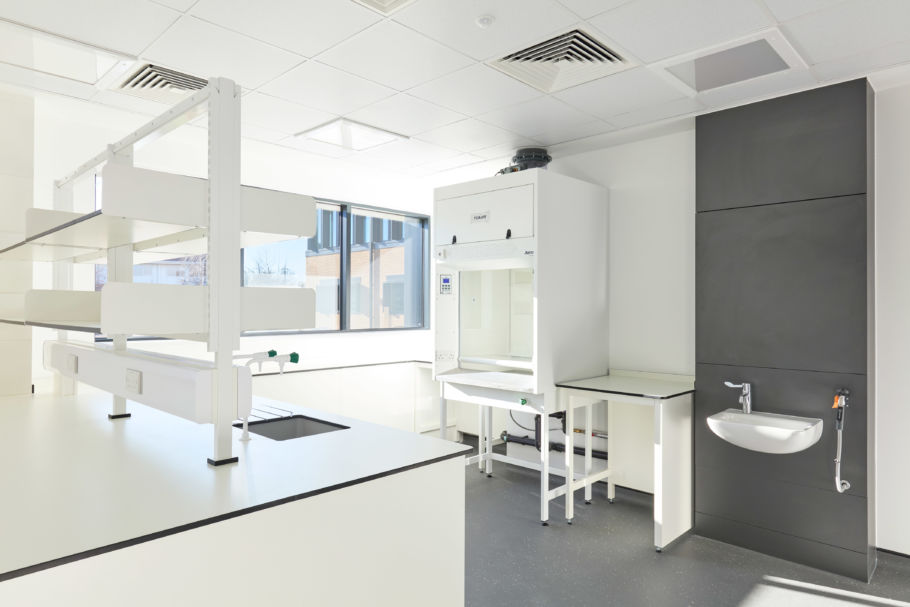 clean, well-lit laboratory with white and gray furniture and a sink