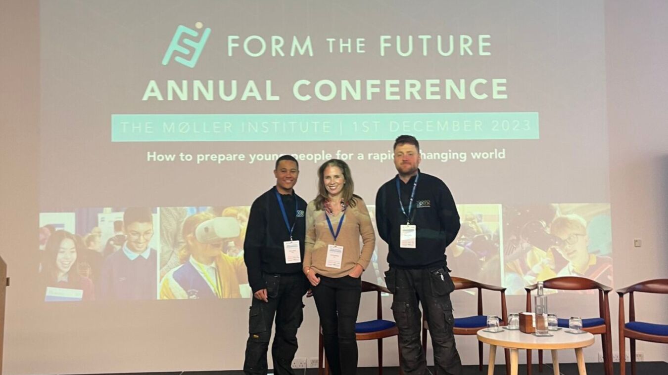 Three people stand smiling in front of a conference presentation screen. The screen displays: "FORM THE FUTURE ANNUAL CONFERENCE, THE MØLLER INSTITUTE, 1ST DECEMBER 2023, How to prepare young people for a rapidly changing world."