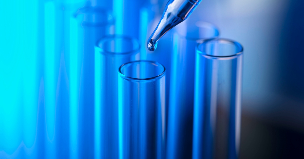 Close-up of pipette dispensing liquid into test tubes, symbolising scientific research and lab services offered by COEL.