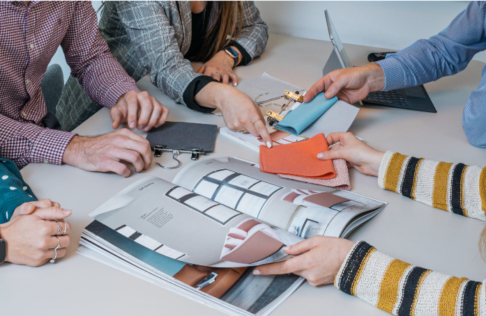 group of people examining interior design materials and a magazine