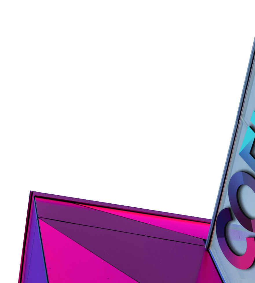 A section of a colorful geometric building facade features bold pink and purple triangular panels alongside a reflective glass panel displaying reversed text 'k' and 'o' against a white sky background.